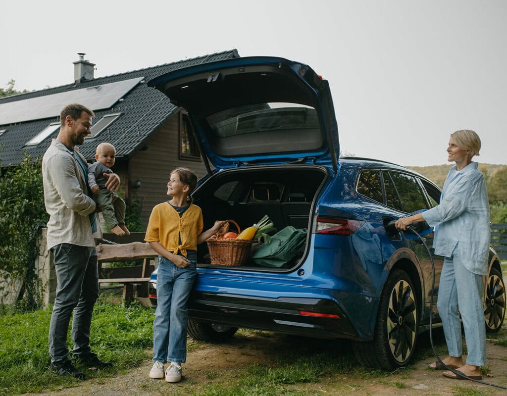 family standing around open car boot