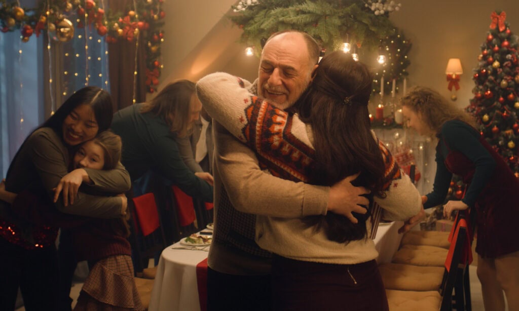 family hugging at christmas dinner paid for with christmas loan